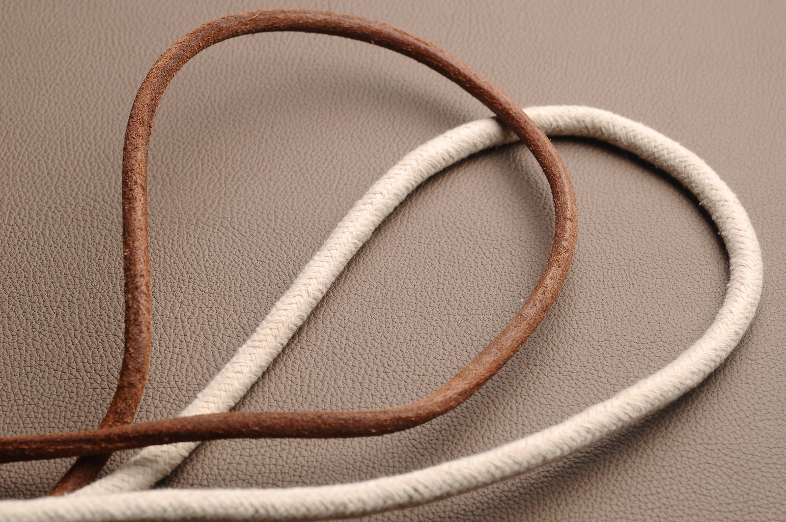 Brown and cream woven straps arranged on a textured material surface
