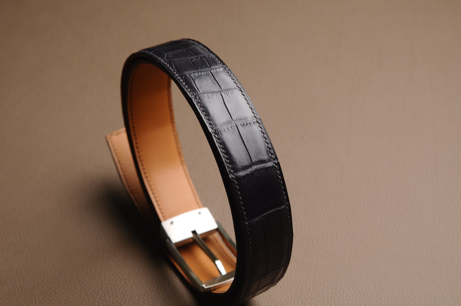 Coiled leather belt showing lining and hardware