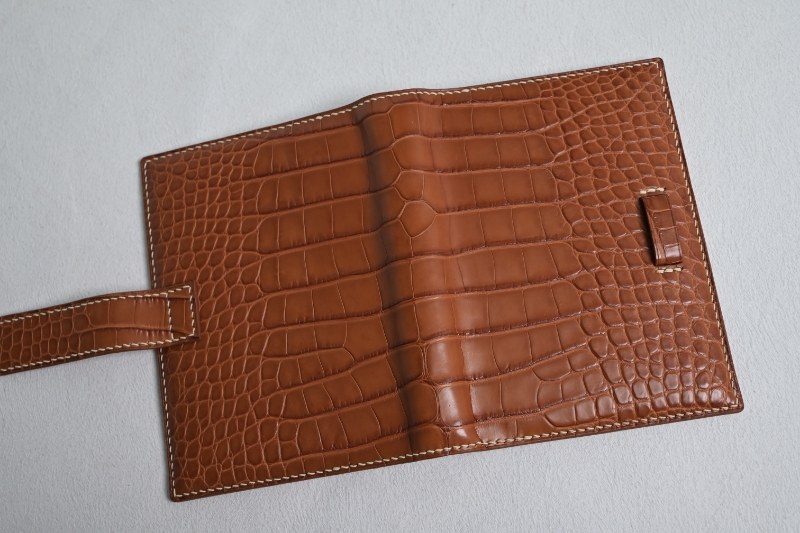 Open leather ring organizer with textured interior and a closure strap