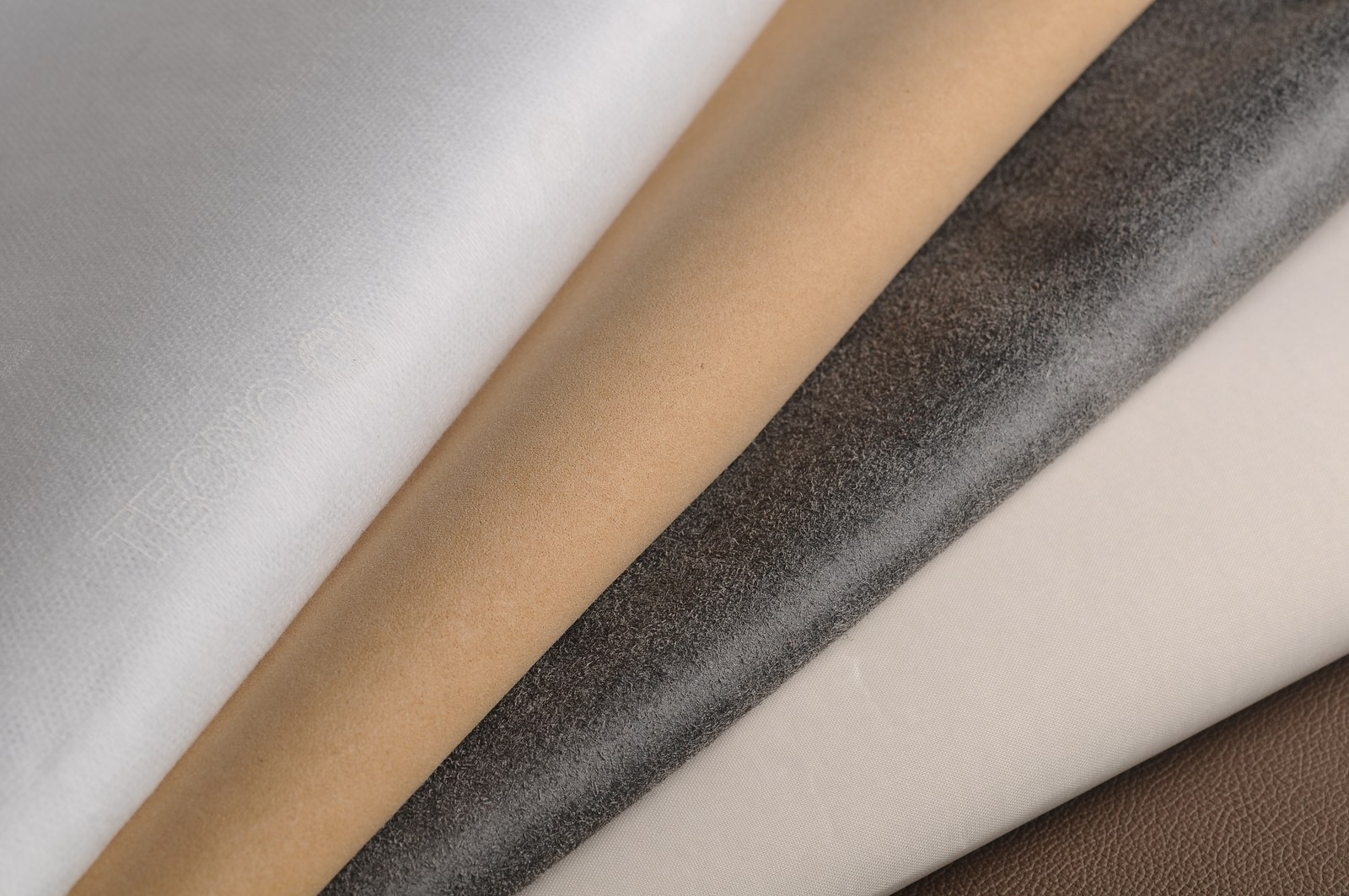 Rolls of white, cream, brown and charcoal lining materials
