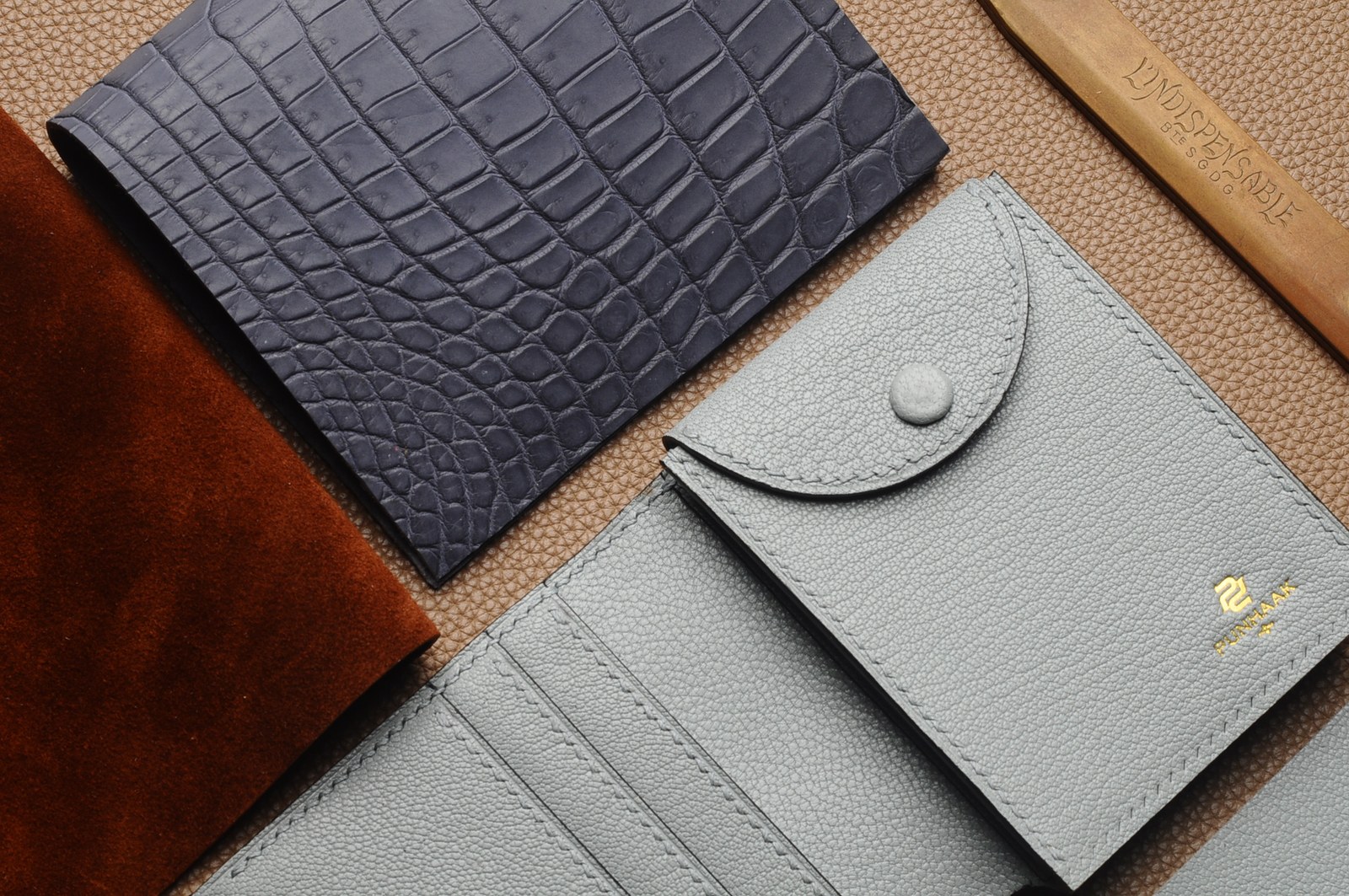 Dark blue crocodile leather and light gray wallet components with material samples