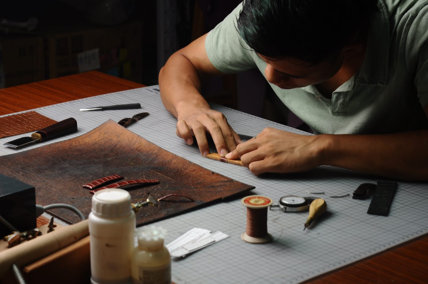 Artisan stitching a leather product in the workshop